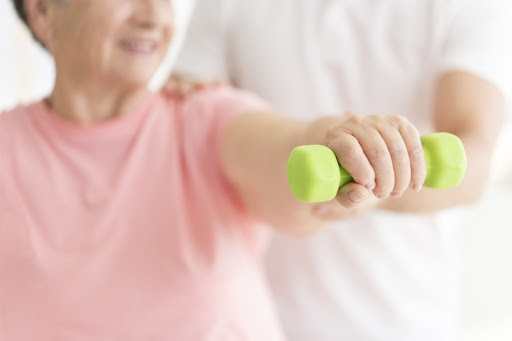 Older Female Using Weghts In A Physical Rehab Session